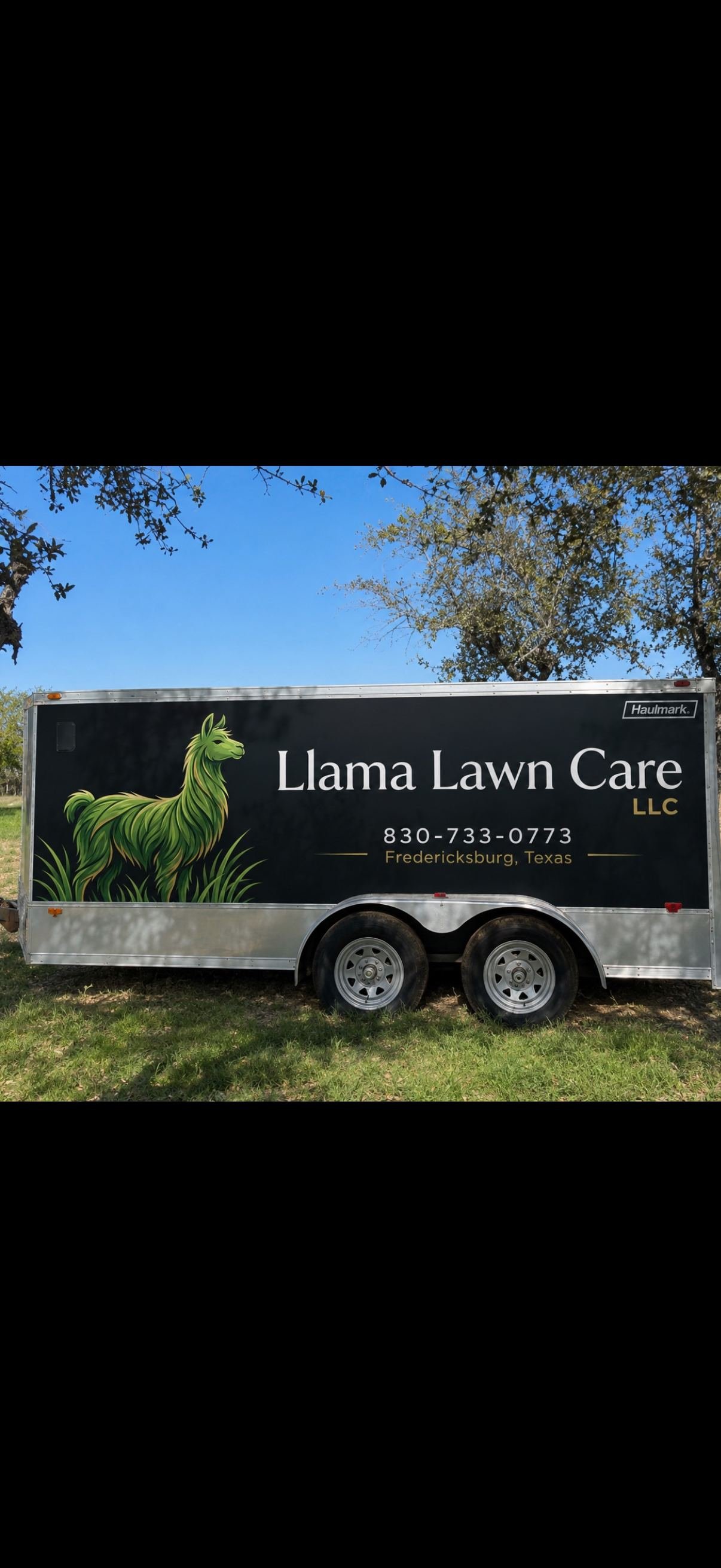 Llama Lawn Care equipment trailer with logo and contact info