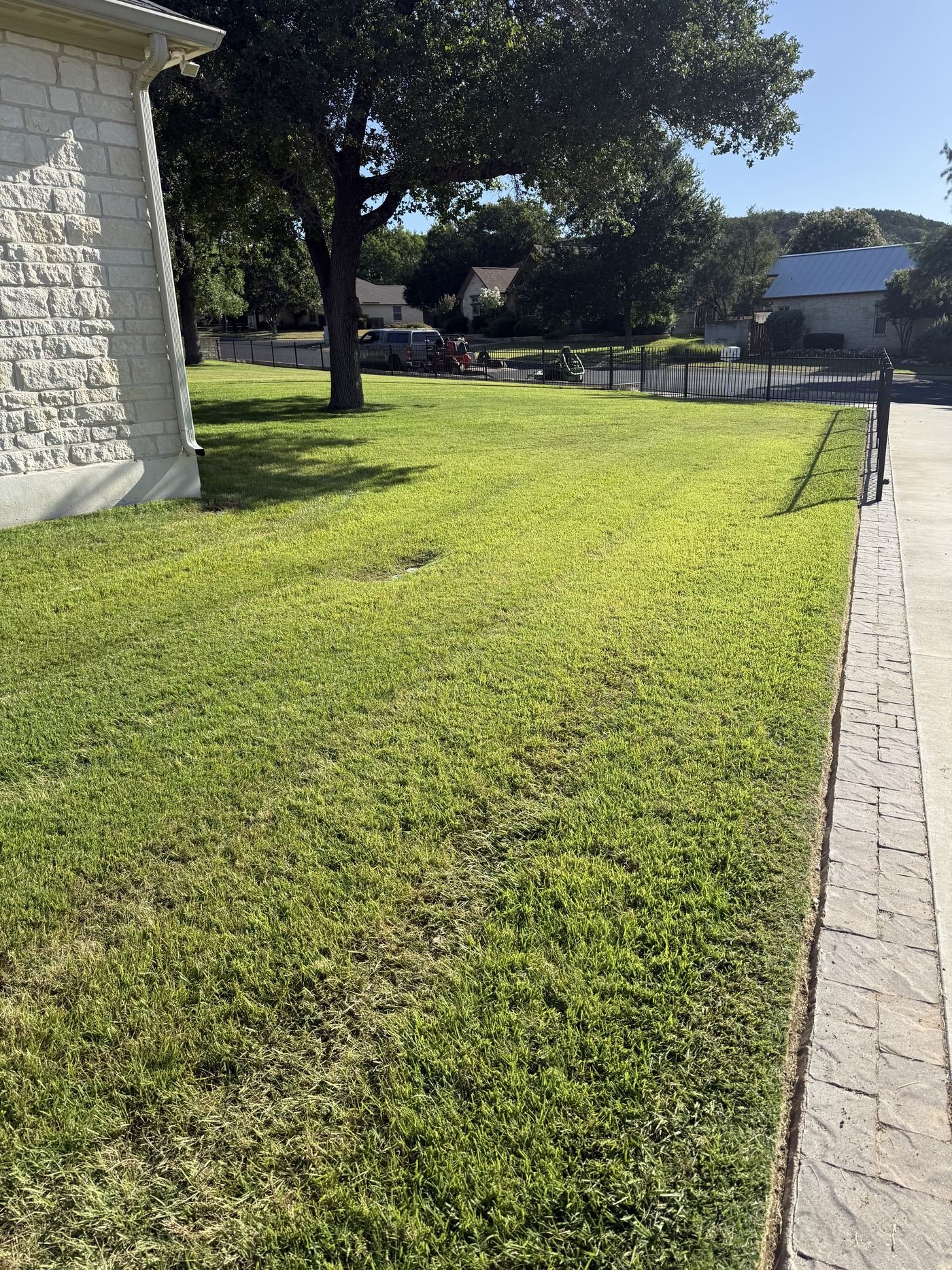 Manicured side lawn of a limestone home